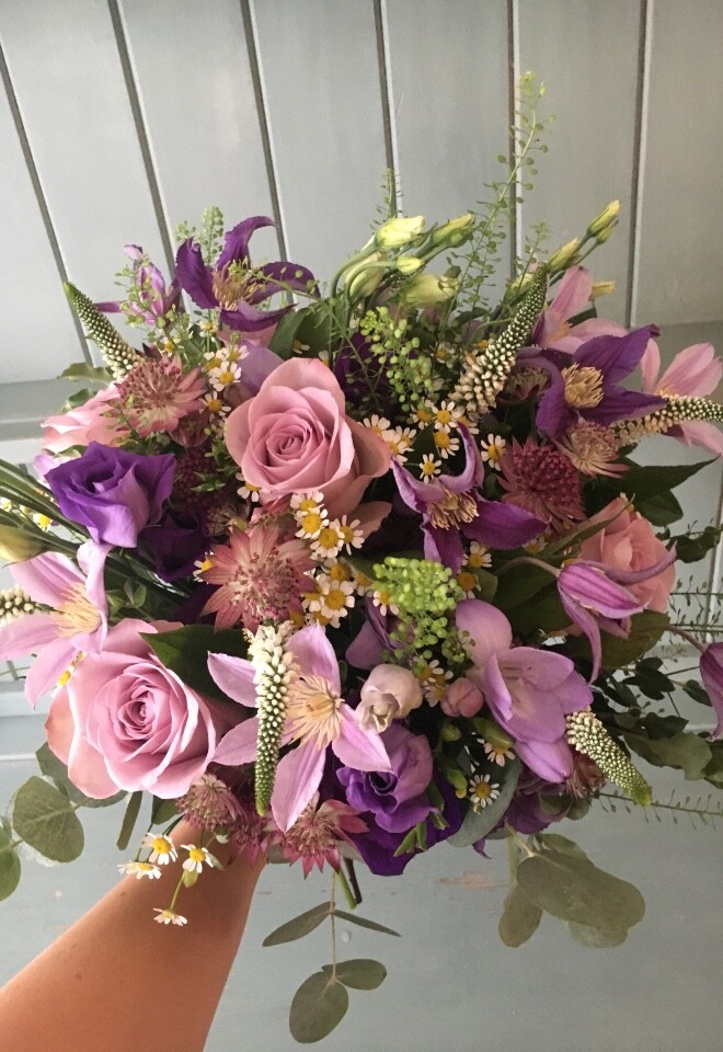 A purple and lilac bridal bouquet with a wild look to it from a wedding at Steventon House Hotel