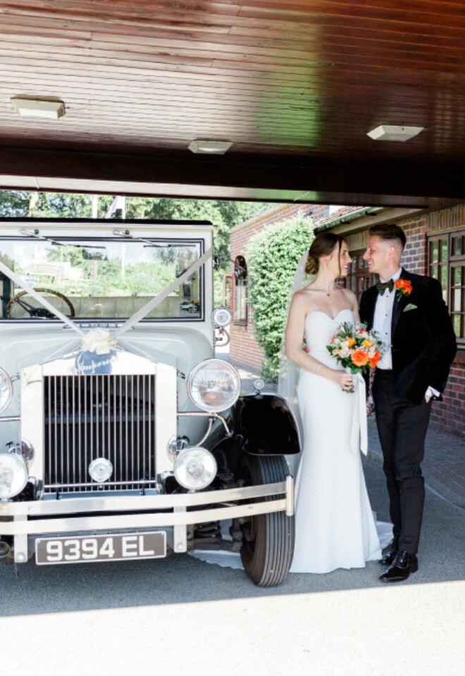 Outside the front of our building with their wedding car