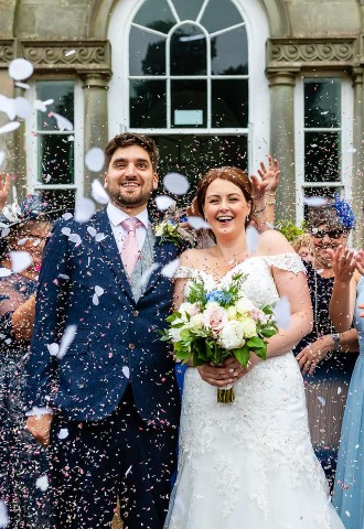 Bride and groom being showered in confetti at Margam Orangery, Neath Port Talbot