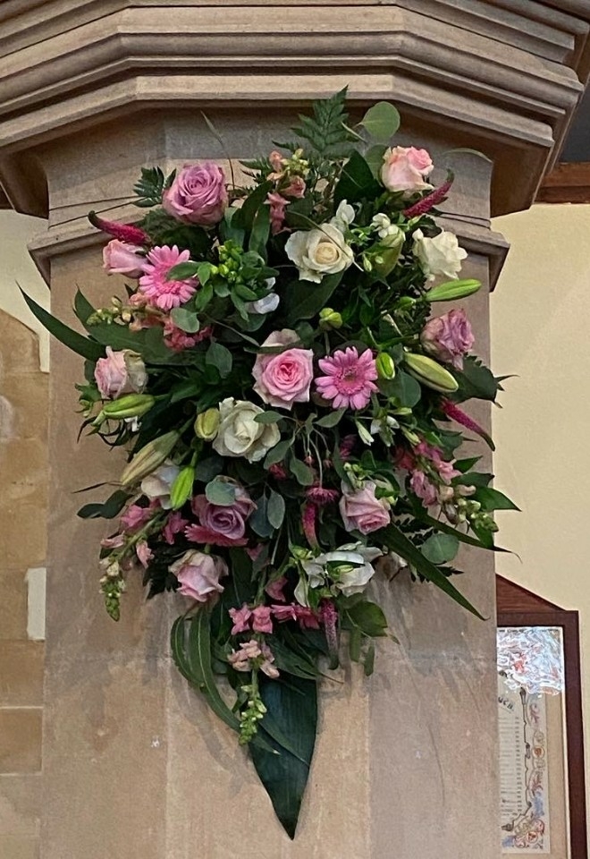 Pink and cream coloured flower display on wall by hire heaven