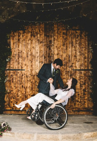 Wheelchair using bride with groom in barn wedding ceremony