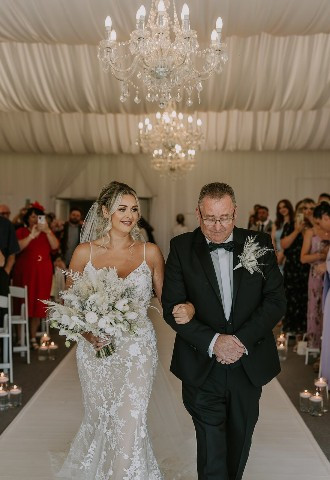 Bride and her father walking down the aisle at Henblas Country Park, Anglesey, North Wales