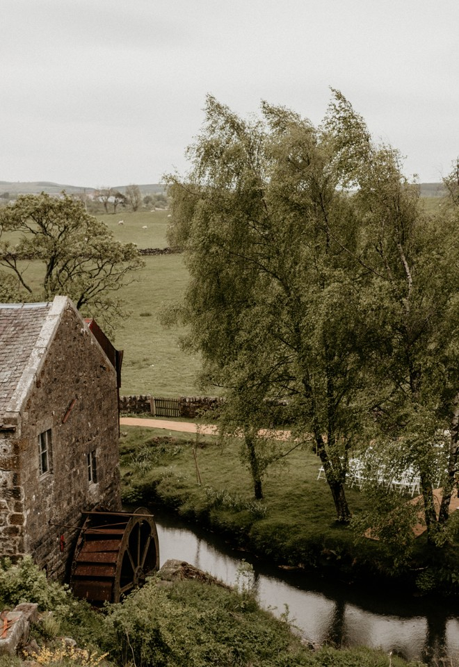 The water wheel on the side of the Mill building overlooking the garden set up for an outdoor ceremony.  Photo by Claire Fleck