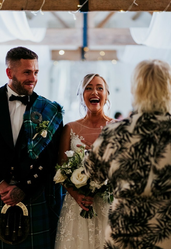 bride and groom laughing with celebrant