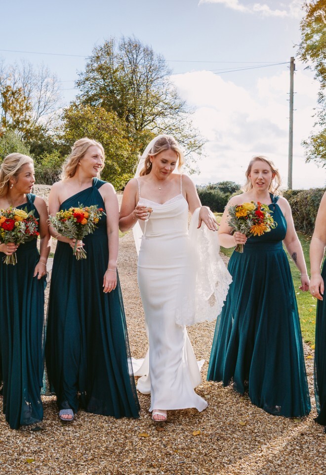 Bride and bridesmaids walking in warm sunshine at Merriscourt wedding venue