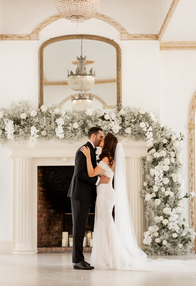 Mantelpiece installation of white roses, orchids and gypsophila at Northbrook Park