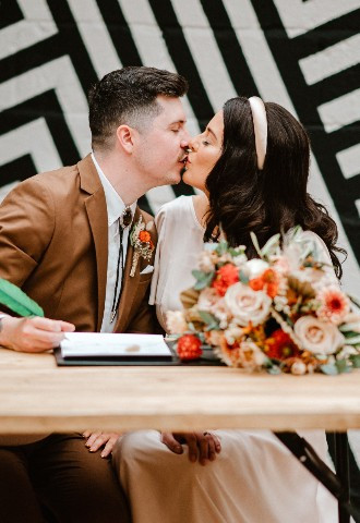 Couple sign register and kiss on wedding day at The Shack Revolution in Hereford