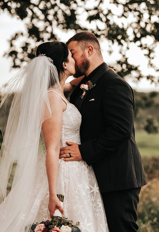 Bride and groom sharing a kiss in the picturesque Cheshire countryside surrounding The Cock O’Barton.