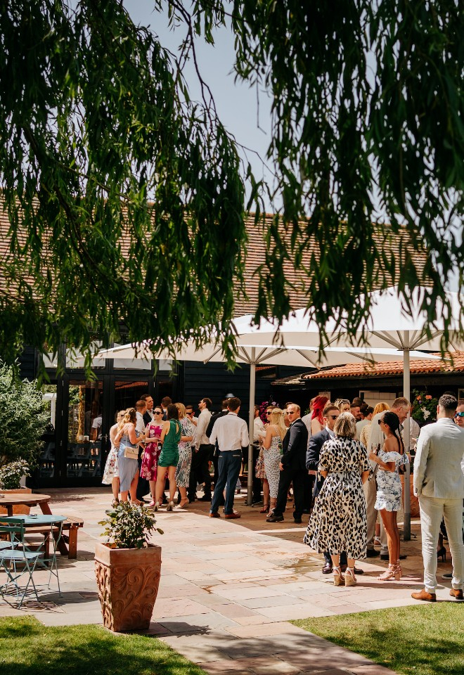 Reception drinks in the stable courtyard at High House Weddings in Essex