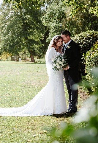 Bride and groom in the grounds at voco Oxford Thames, Oxfordshire