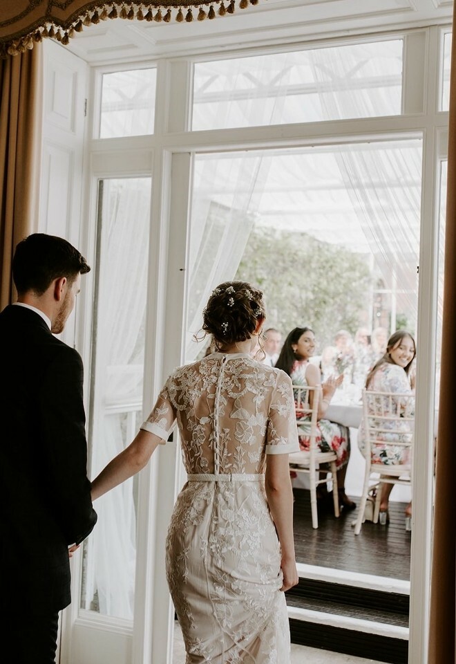 Bride and groom enter conservatory for wedding reception