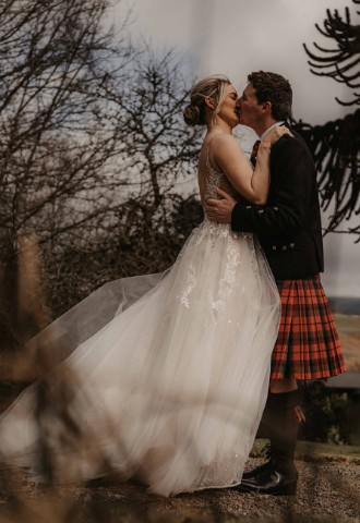 Bride and groom kissing at Auchen Castle - a romantic castle wedding venue in Scotland