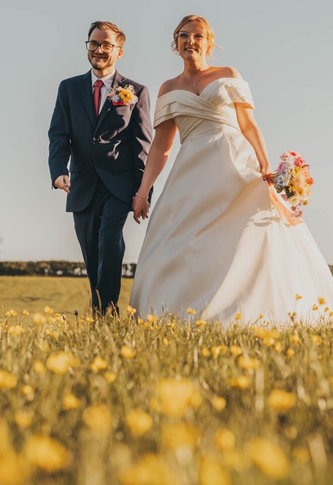bride and groom in the dandelions at The Pear Tree wedding venue.
