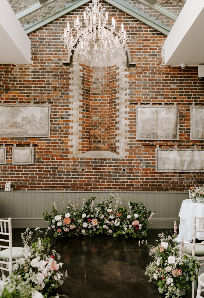 Floral meadow designs of spring flowers for ceremony in the conservatory at Offley Place