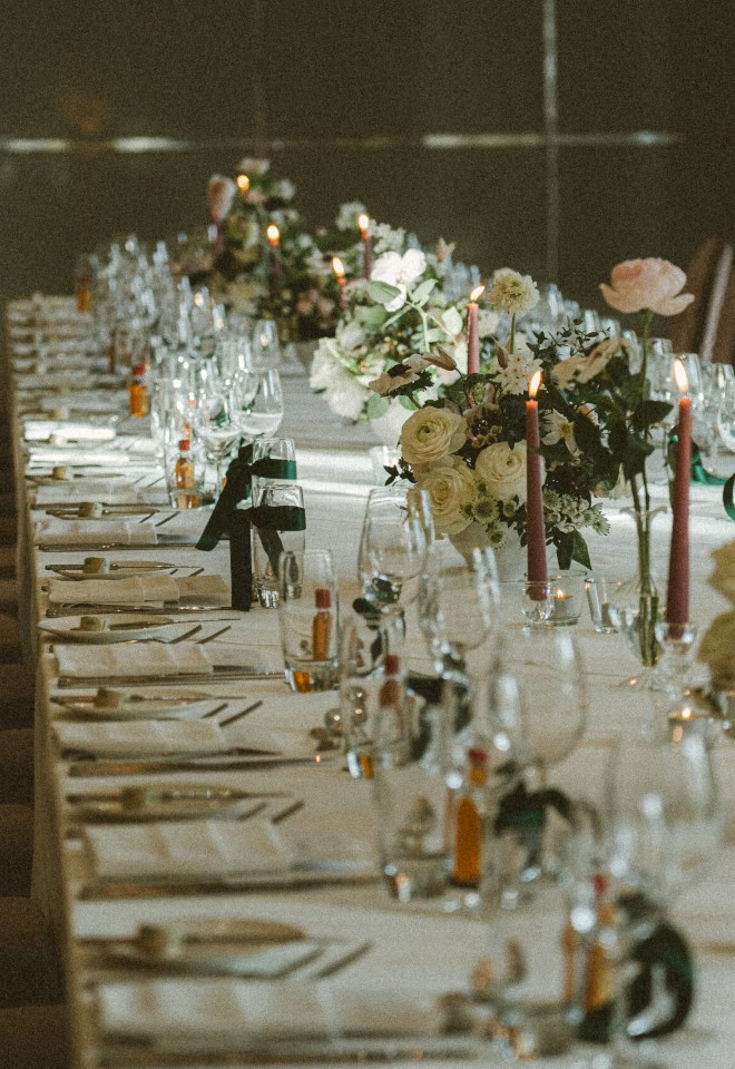 Wild Fig Flowers wedding reception table in Oxfordshire, decorated with elegant white floral arrangements, greenery and soft pink candles.