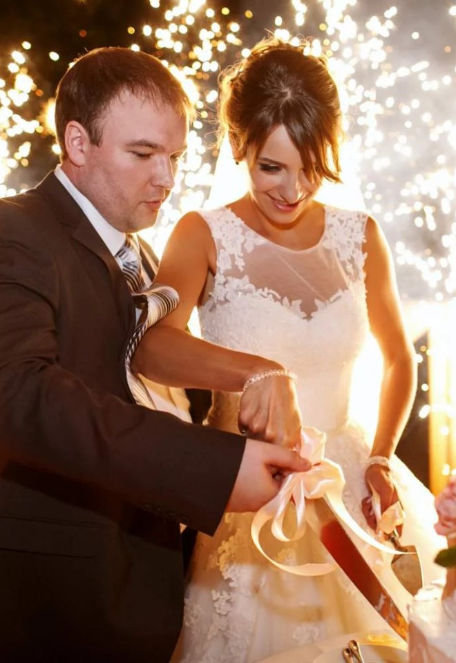 Bride and groom cutting their wedding cake surrounded by spectacular indoor spark fountains from Berkshire-based Star Fireworks.