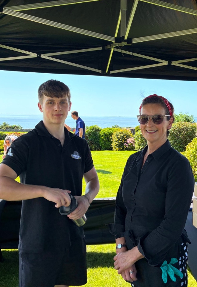 Hog roast catering team serving guests at an outdoor wedding