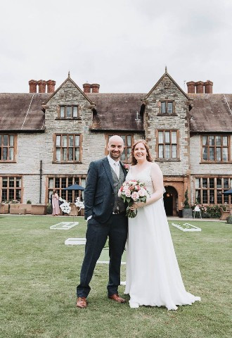 Exterior of Billesley Manor Wedding Venue Warwickshire with wedding couple