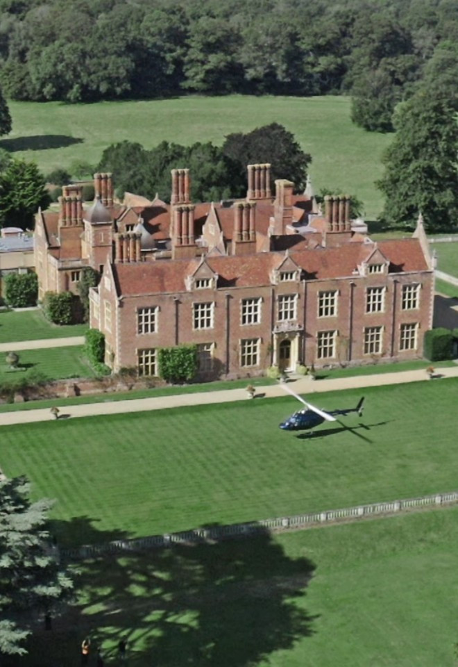 Aerial view of North Mymms Park estate showing the historic mansion house, surrounding manicured gardens, formal hedges, and a helicopter landing on the front lawn.