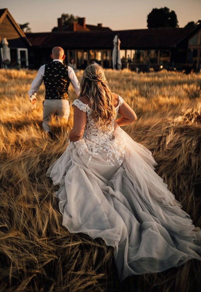 Bride and Groom running through the cornfield that surround Vaulty Manor