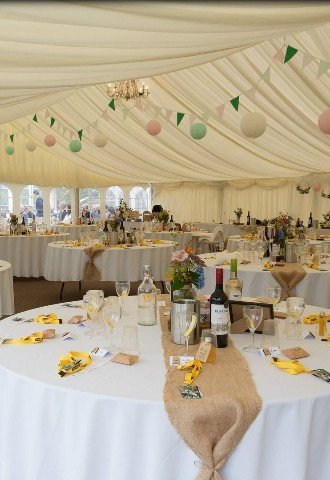 Wedding breakfast set up inside marquee at The Stables Wedding Farm