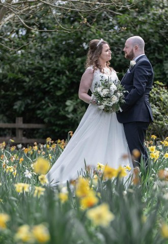 Bride and groom standing in a field of daffodils, Matt Clarke Photography, West Midlands