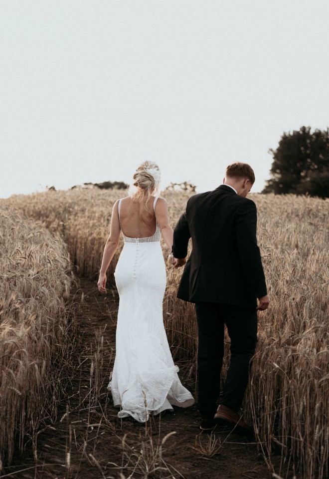 Happy Couple Walking through the Corn at Grange Barn Wedding Venue