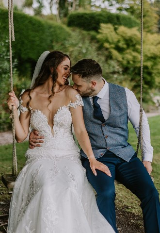 Bride and groom resting on a swing at Chateau Rhianfa, North Wales