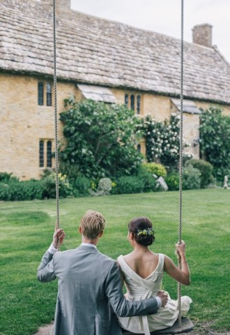 Couple sitting on a swing outside of Bailiffscourt wedding venue in Sussex