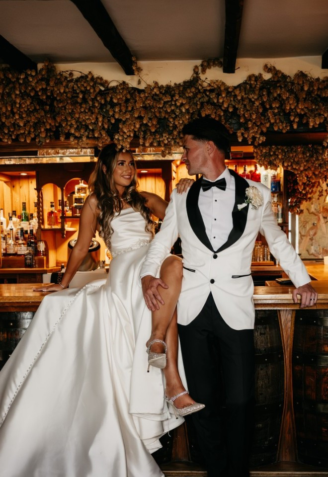 Bride and groom pose in the 16th century private pub at The Harty Estate