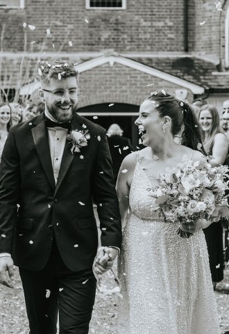 Wedding couple walking through confetti tunnel after Wedding Ceremony at the Kings Chapel Wedding Venue in Amersham Buckinghamshire