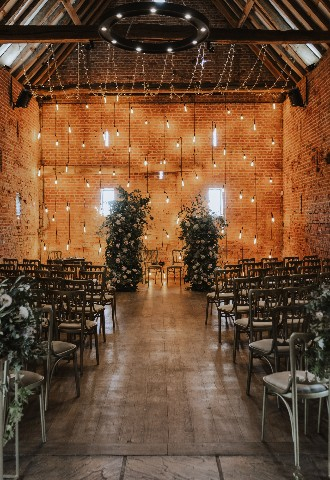 Copdock Hall set up for a wedding ceremony with fairy lights as the backdrop