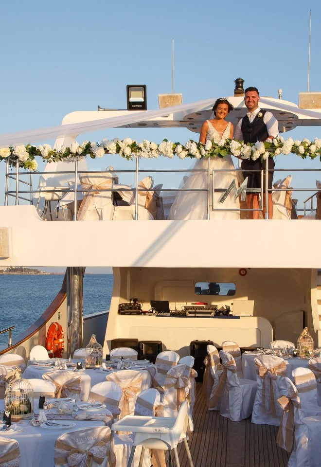 Bride and groom standing on the deck of a boat for their wedding in cyprus