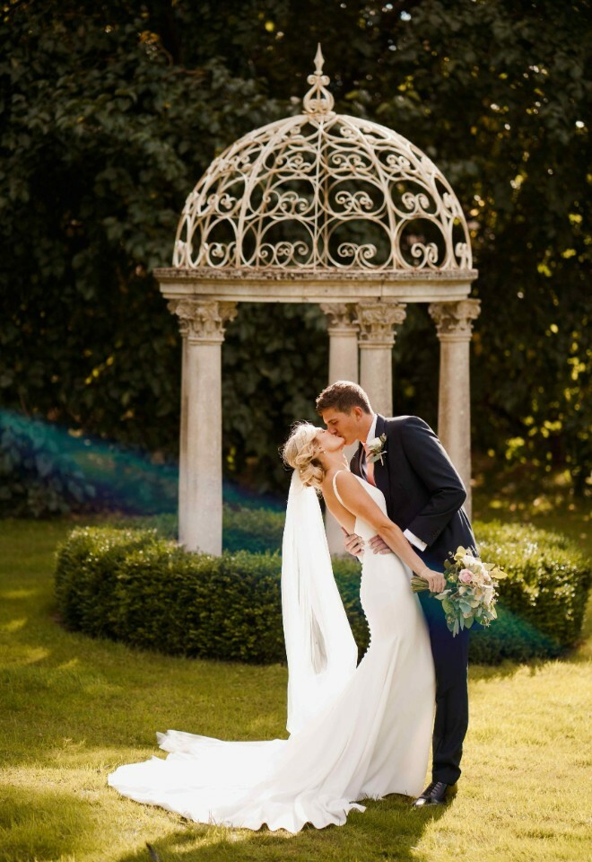 Bride and groom kiss in Sutton Bonington Hall gardens