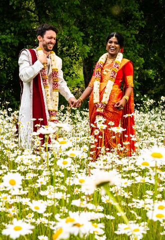 Bride and groom in a beautiful daisy meadow at Sheepdrove Farm