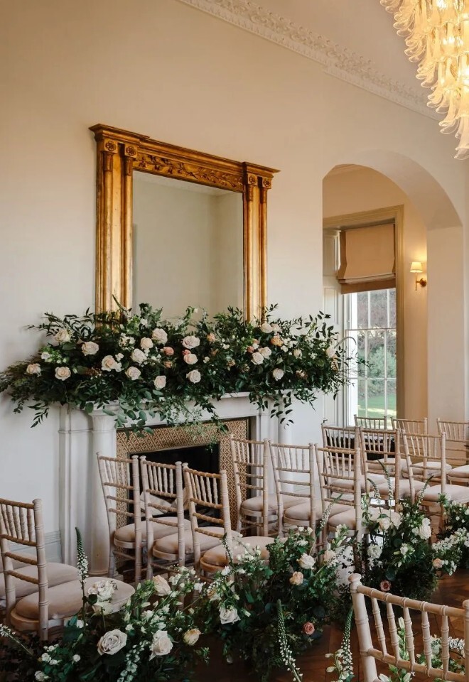 Intimate wedding ceremony setup at Henlade House wedding venue in Somerset, framed by tall windows and garden views.