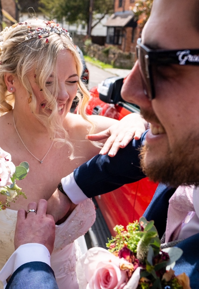 Groom clearing confetti from the brides cleavage