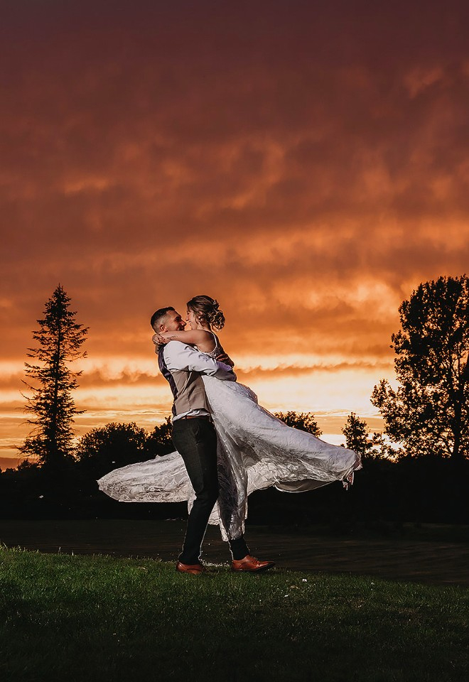 Bride and groom dancing under amazing sunset