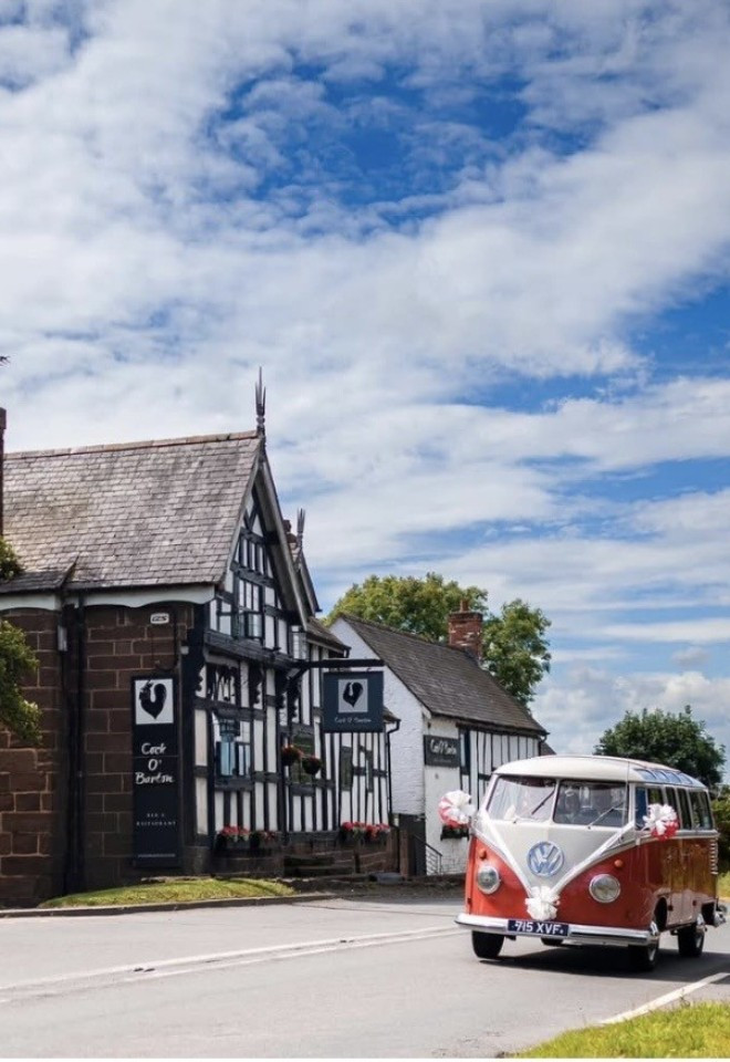 Vintage Volkswagen campervan arriving outside The Cock O’Barton wedding venue in Cheshire.