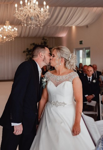 Bride and groom share their first kiss at Henblas Country Park, Anglesey, North Wales
