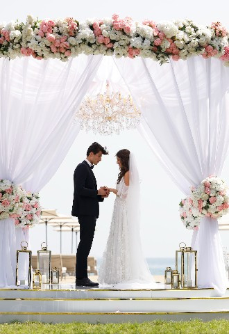 Palace Beach Resort Fujairah wedding with floral curtain arch and bride and groom