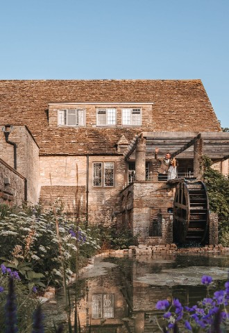 Bride and groom waving on terrace at The Frogmill