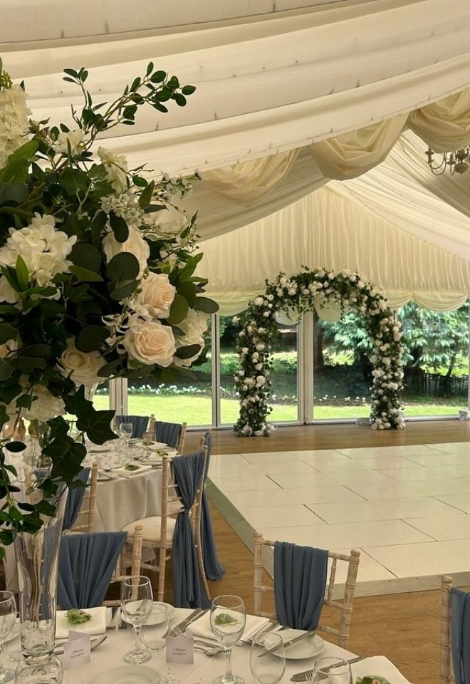 blue chair sashes, floral table decorations & flower arch for marquee wedding buckinghamshire