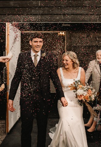 Bride and groom being showered in confetti at Henblas Country Park, Anglesey, North Wales