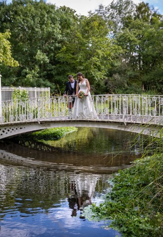 Wedding couple photo on bridge overlooking river at Morden Hall South London