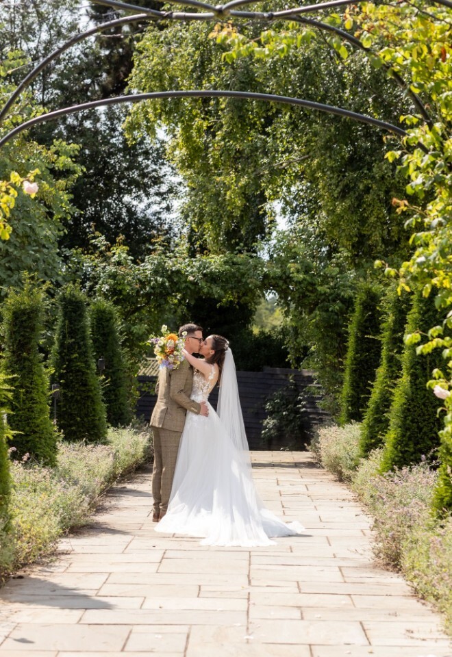 A bride and groom standing in the country grounds of a Warwickshire wedding venue