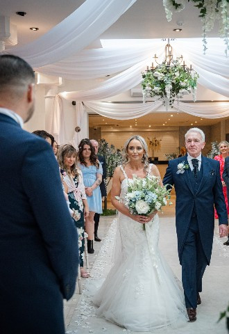 Bride walking down the aisle at Gibbon Bridge Hotel, Lancashire