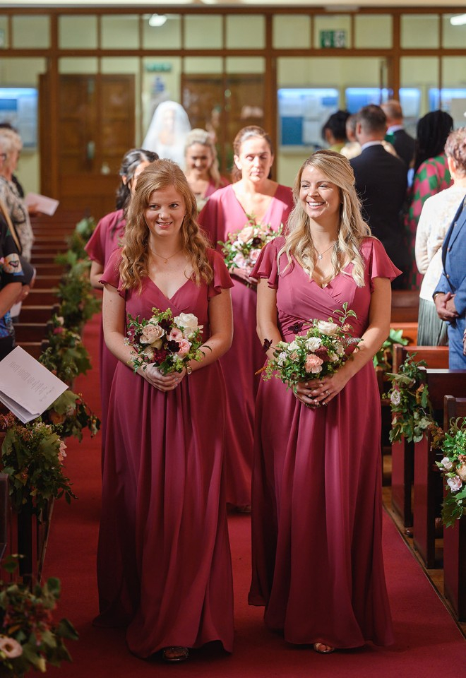 Bridesmaid bouquets and pew ends in rich autumn tones of pink, blush, burgundy and rust, for ceremony at St Albans