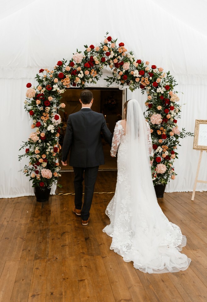 Onsite florist team created a stunning blush and burgundy pallet statement archway 