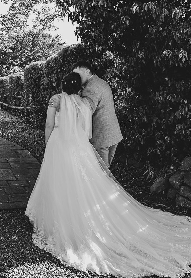 Newlyweds sharing a quiet moment together in the gardens at The Cock O’Barton.